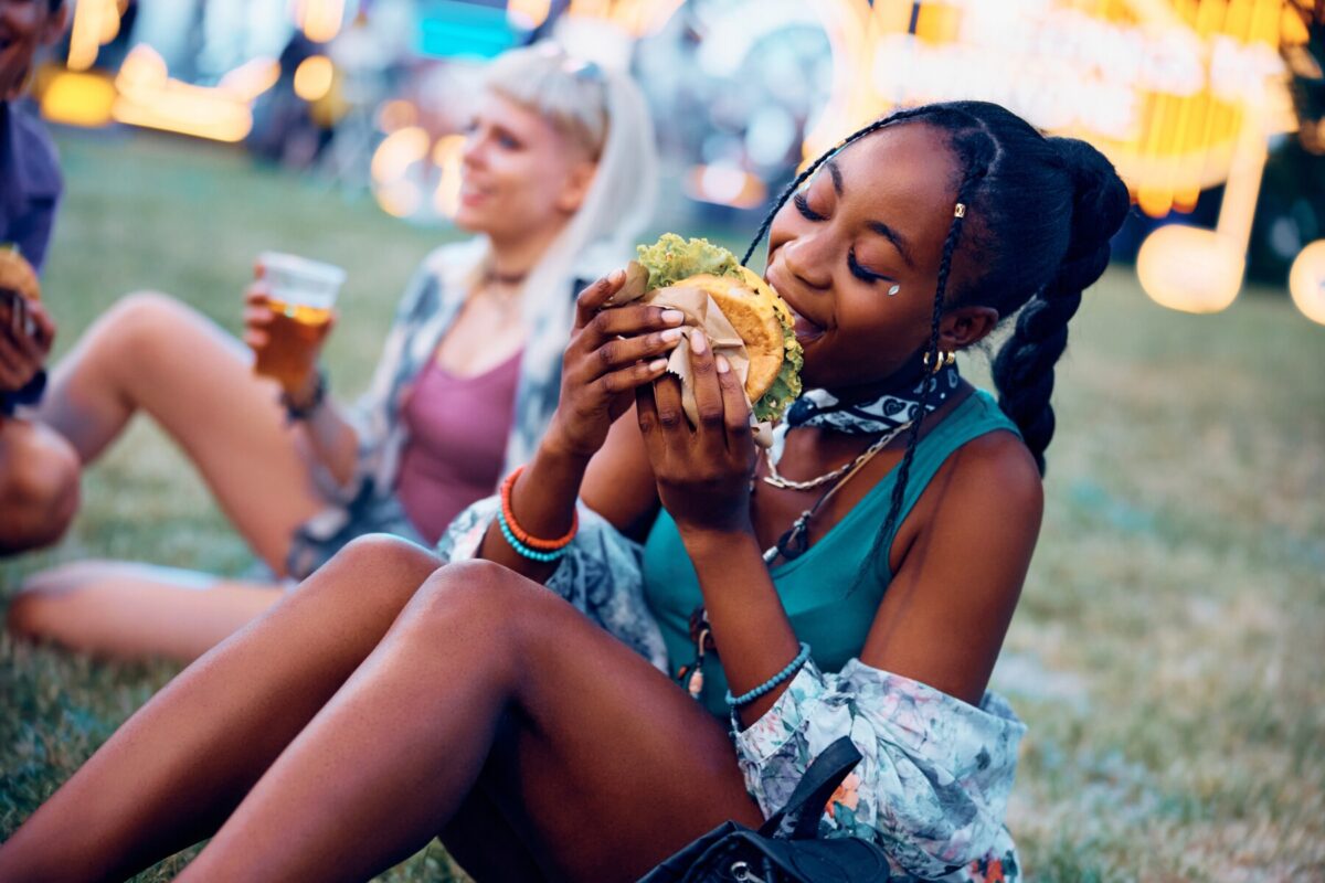 woman eating a burger at a music festival