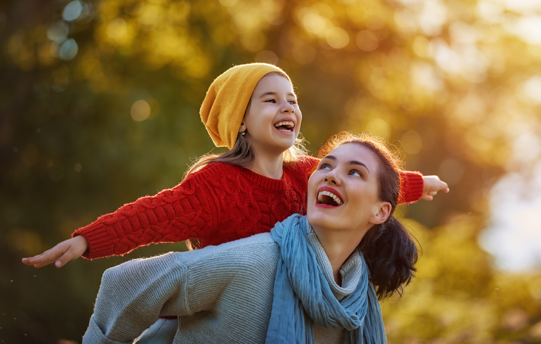 mother and daughter walking in fall leaves
