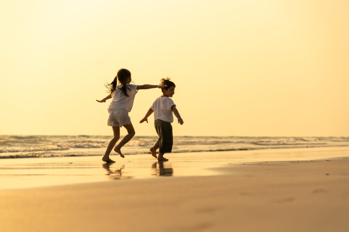 kids running on the sand at sunset